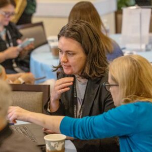 Two attendees discussing what's on the laptop