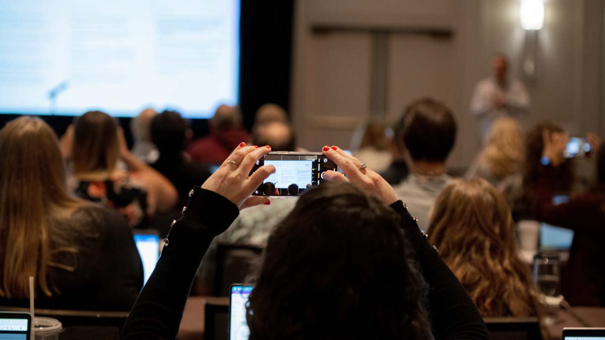 Attendees using their phones to photograph the presentation screen